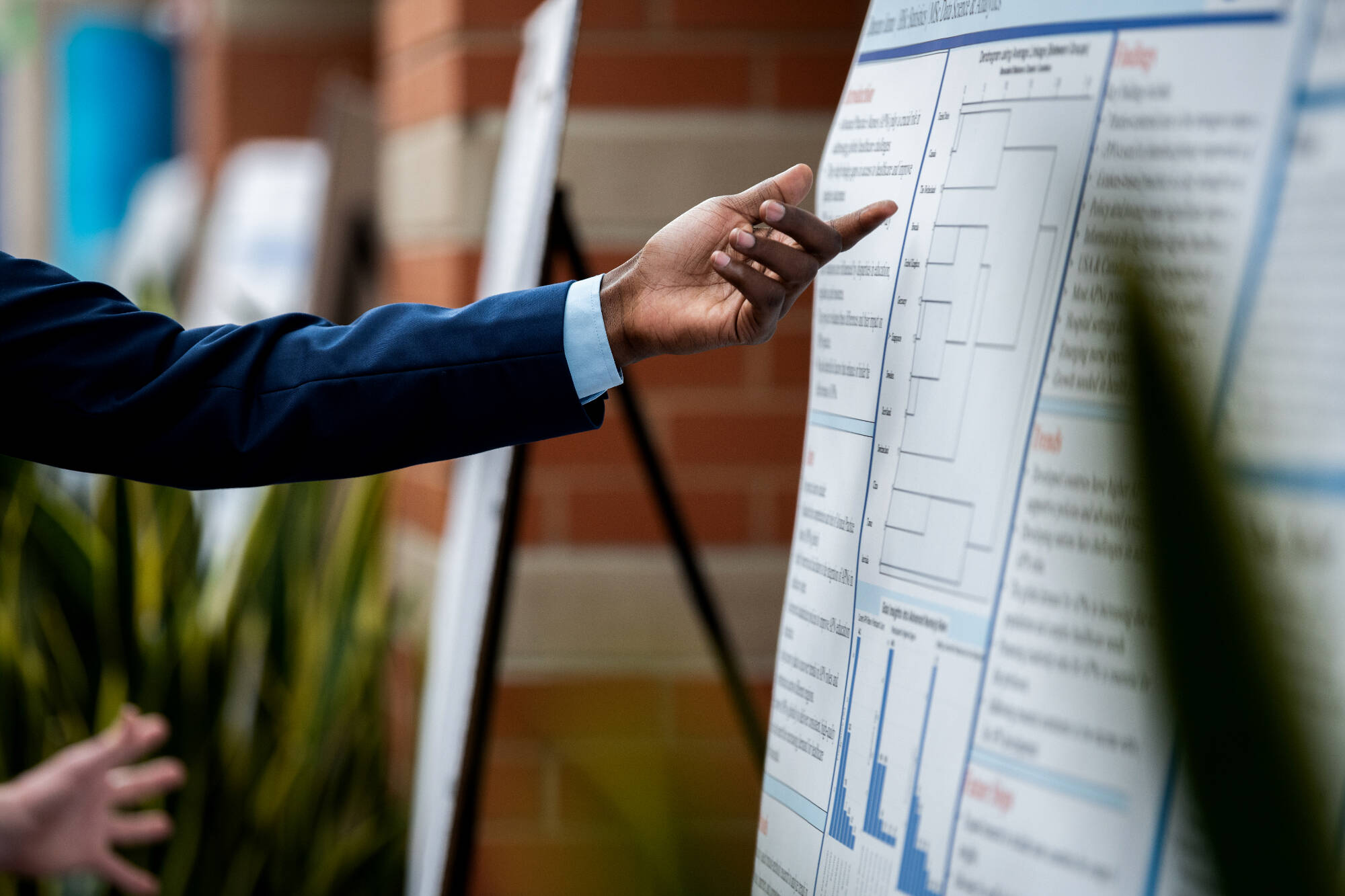 A finger pointing to data on a large chart.